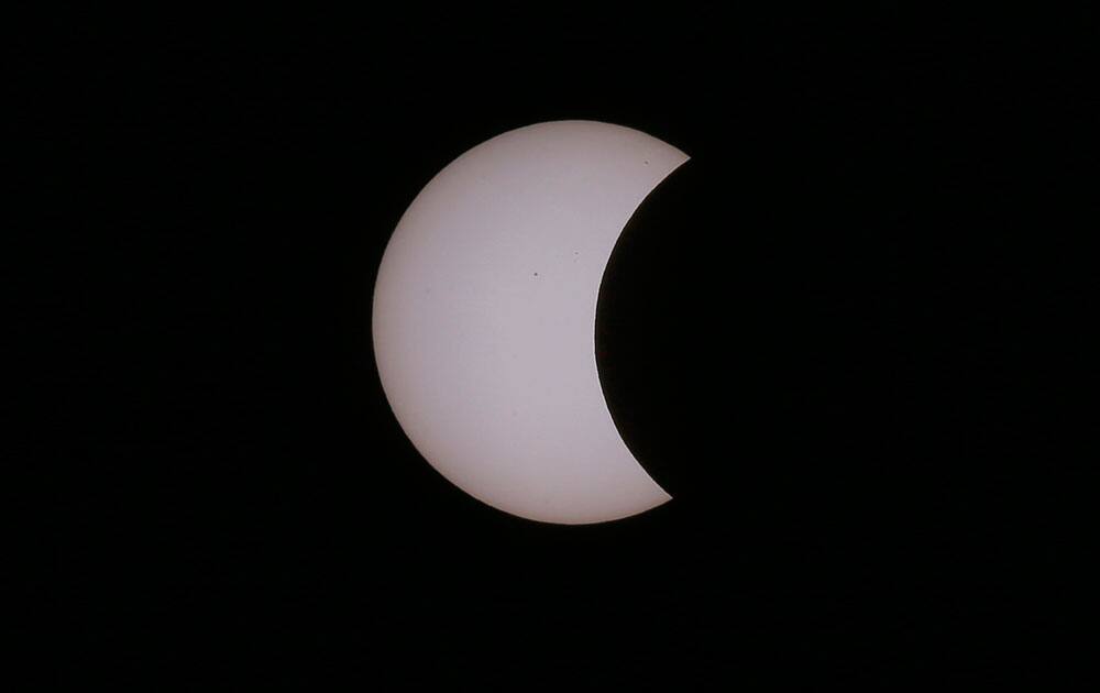 A partial solar eclipse occurs as seen from Taguig city, east of Manila, Philippines.