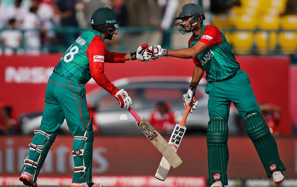 Bangladesh's Tamim Iqbal and Mahmudullah cheer each other as they bat during the ICC World Twenty20 2016 cricket tournament against Netherlands at the Himachal Pradesh Cricket Association (HPCA) stadium in Dharmsala.