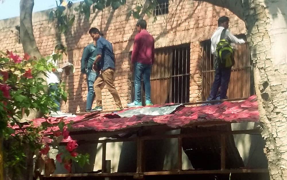 A group of boys throwing cheating material for the students through the windows of a hall at a center for the board examinations in Gurgaon.
