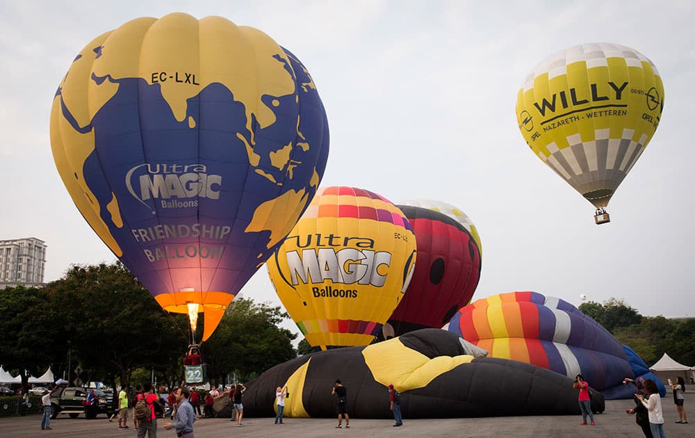 Participants prepare to take off for their first flight at the start of the Putrajaya Hot Air Balloon Fiesta in Putrajaya, Malaysia.