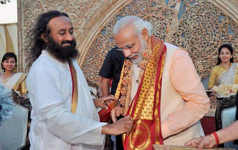 Prime Minister Narendra Modi being greeted by Art of Living founder Sri Sri Ravishankar during the opening day of the three-day long World Culture Festival on the banks of Yamuna River in New Delhi.