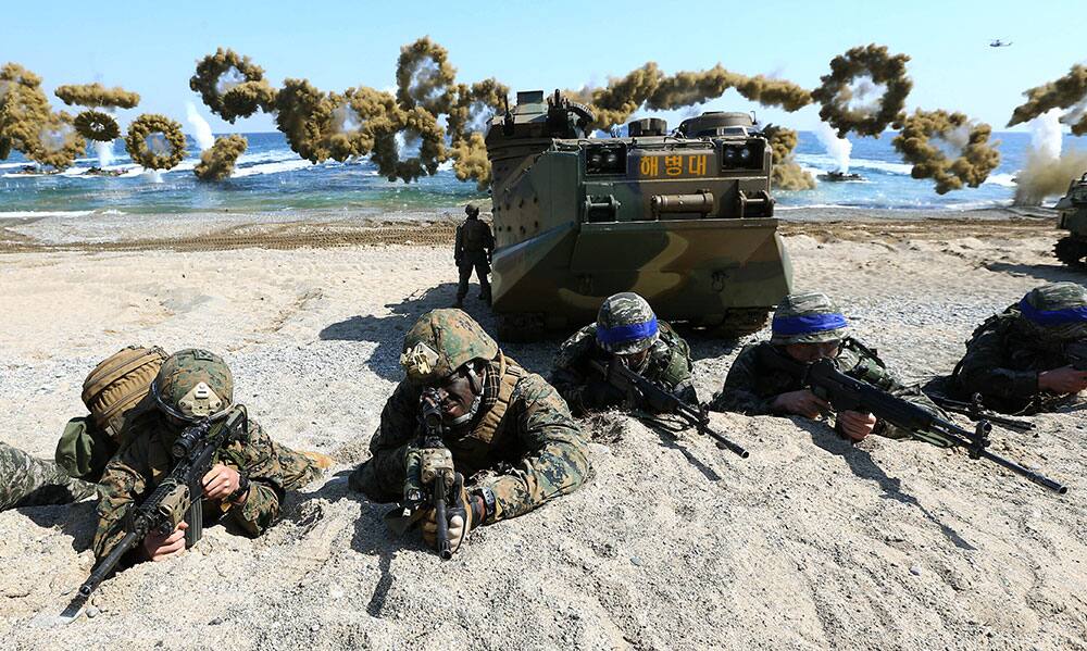 US Marines and South Korean Marines, wearing blue headbands on their helmets, take positions after landing on the beach during the joint military combined amphibious exercise, called Ssangyong, part of the Key Resolve and Foal Eagle military exercises, in Pohang, South Korea
