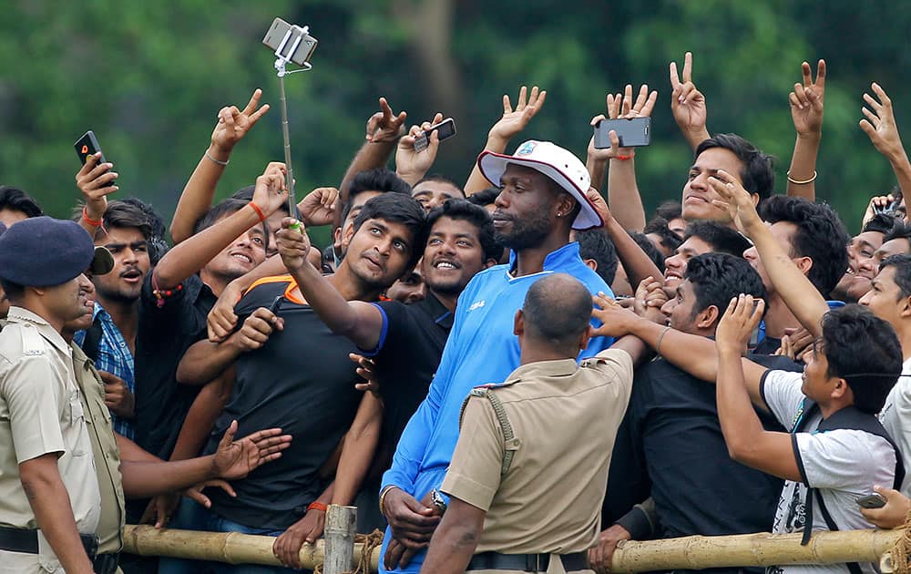 West Indies bowling coach Curtley Ambrose poses for a selfie with Indian fans during a training session prior to their practice match of the ICC World Twenty20 2016 cricket tournament in Kolkata.