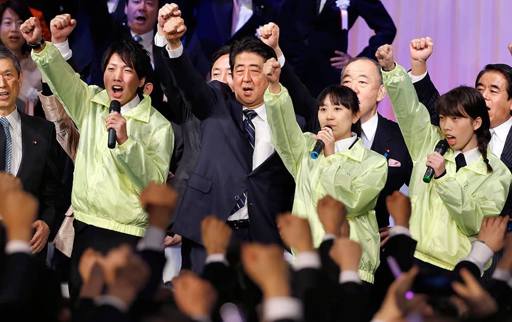 Japanese Prime Minister Shinzo Abe, center, punches the air with lawmakers and supporters during his ruling Liberal Democratic Party's annual convention in Tokyo.