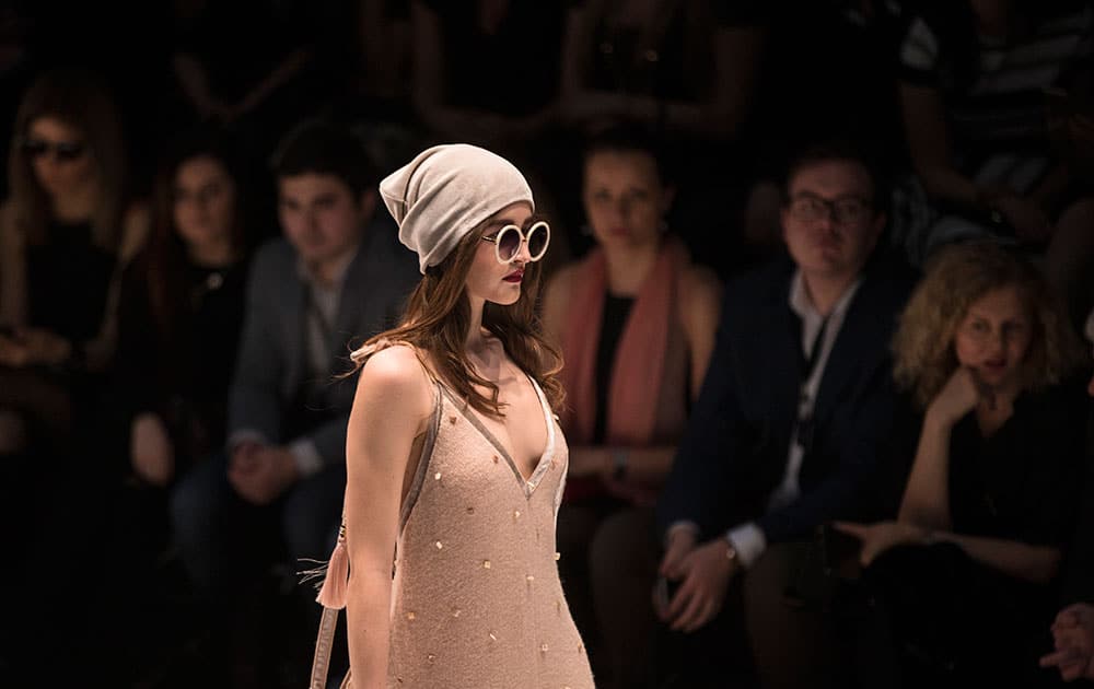 People watch as a model displays a creation of Russian designer Julia Dalakian during Mercedes-Benz Fashion Week in Moscow.