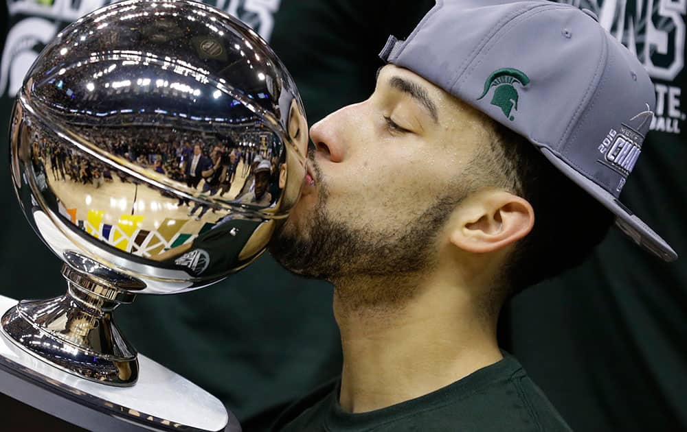 Michigan State's Denzel Valentine (45) kisses the championship trophy after an NCAA college basketball game against Purdue in the finals at the Big Ten Conference tournament.