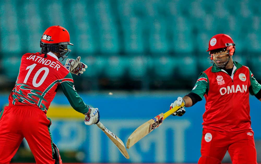 Oman's Amir Ali, right, and Jatinder Singh touch bats during the ICC World Twenty20 2016 cricket tournament against Bangladesh at the Himachal Pradesh Cricket Association (HPCA) stadium in Dharamsala.