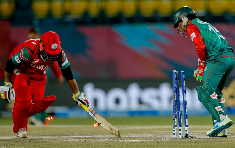 Oman's Amir Ali, left is stumped by Bangladesh's Mushfiqur Rahim during the ICC World Twenty20 2016 cricket tournament at the Himachal Pradesh Cricket Association (HPCA) stadium in Dharamsala.