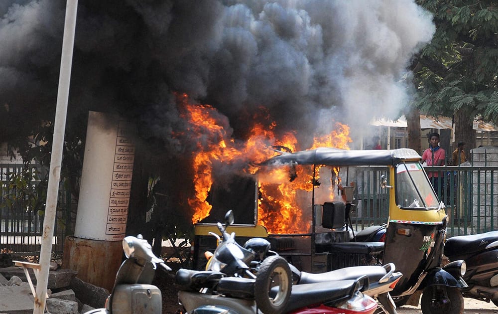 An autorickshaw burns in a stray violence by the BJP workers during a bandh called over the murder of a party leader, in Mysuru.