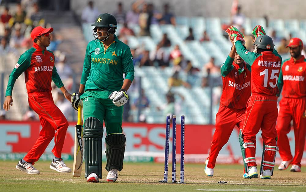 Pakistan's Sharjeel Khan walks back to pavilion as Bangladesh cricket team players celebrate his wicket during the ICC World Twenty20 2016 cricket tournament in Kolkata.