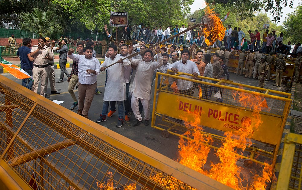 Activists of youth wing of Congress party shout anti-government slogans and burn an effigy during a protest against businessman Vijay Mallya in New Delhi.