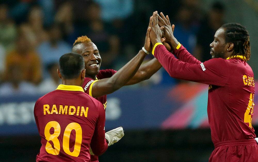 West Indies Andre Russell, left, celebrates the wicket of England's Jason Roy during their ICC World Twenty20 2016 cricket match at the Wankhede stadium in Mumbai.