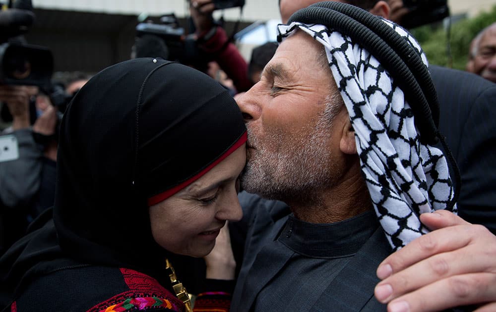 Palestinian teacher Hanan al-Hroub, left is kissed by her father Hamed Obeidallah during a welcome ceremony upon her arrival back home, in the West Bank city Jericho.