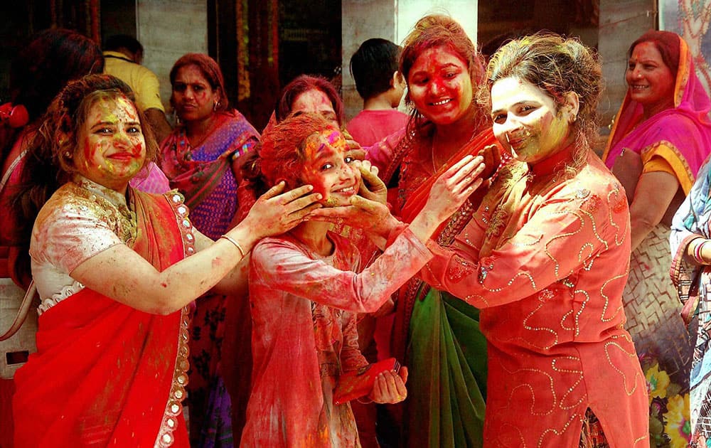 People color each other with colored powder gulaal as they take part in Fagotsav ceremony at Gangshaym Temple in Jodhpur.