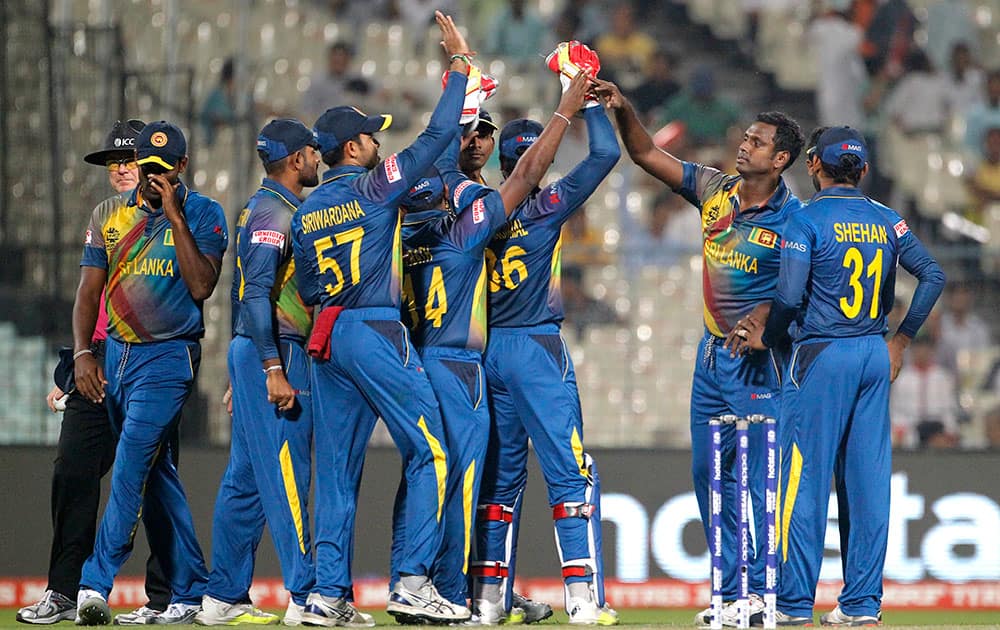 Sri Lanka's Angelo Mathews is congratulated by teammates after dismissing Afghanistan’s Shahzad Mohammad during their match at the ICC World Twenty20 2016 cricket tournament in Kolkata.