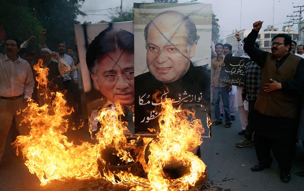 Supporters of Pakistans opposition Peoples Party burn pictures of former Pakistani military ruler Pervez Musharraf, left, and Pakistani Premier Nawaz Sharif during a protest to condemn the departure of Musharraf, in Lahore.