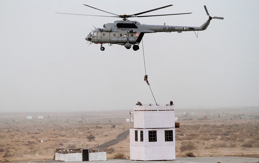A soldier is dropped on a rooftop from a helicopter during exercise 'Iron Fist' at Pokhran.