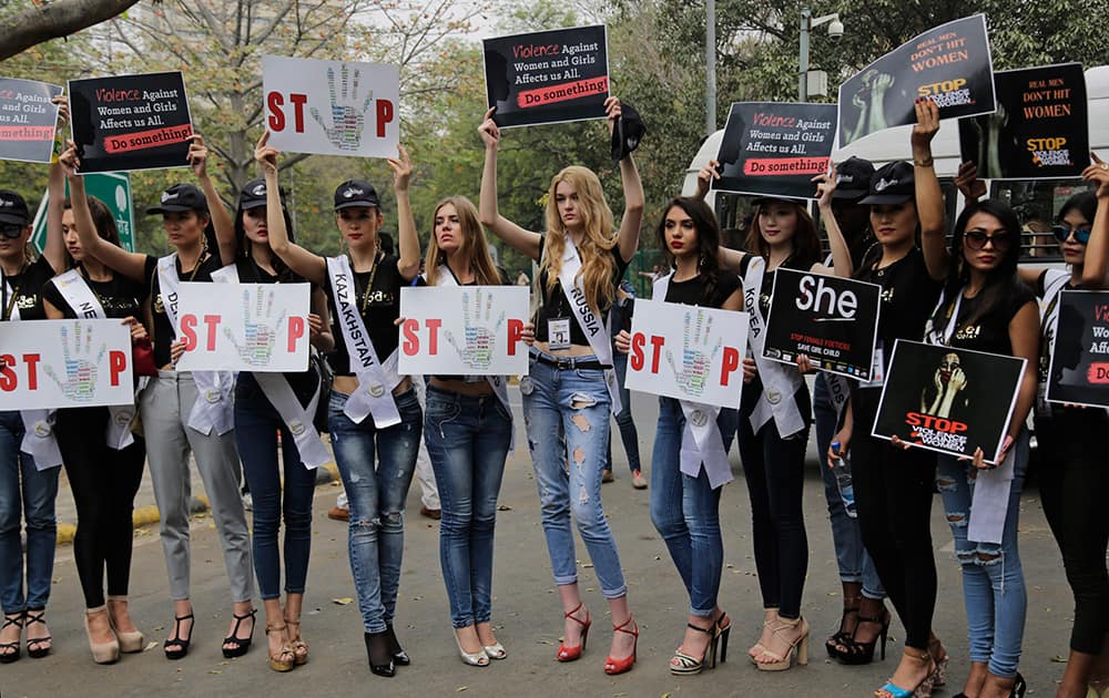 Models from various countries carry placards as they participate in a march demanding an end to crimes against the girl child and women at Jantar Mantar, an area near the Indian parliament where citizens from across the country assemble for protests, in New Delhi.