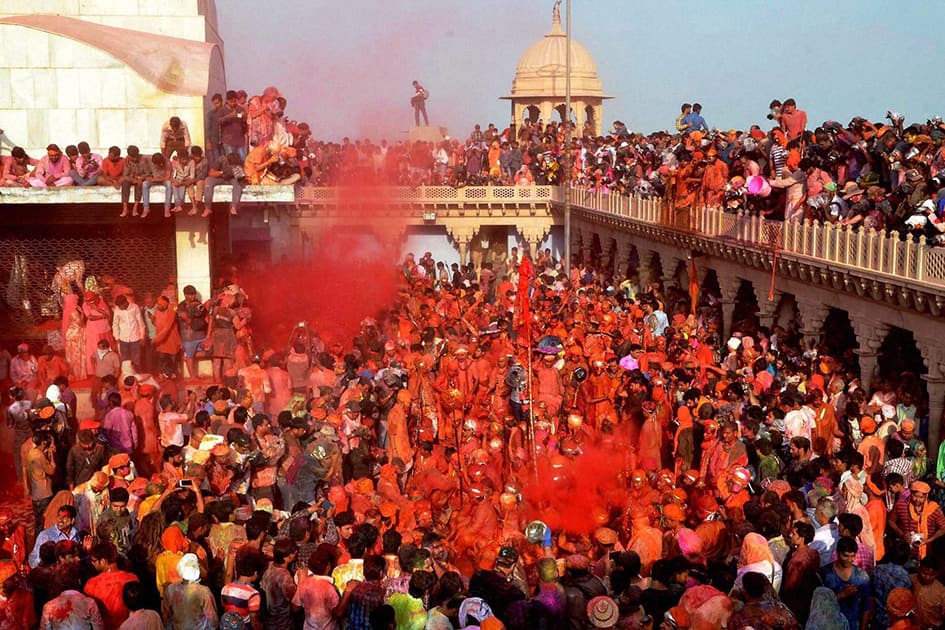 People daub each other with colors during Latthmaar Holi celebrations in Nandgaon near Mathura.