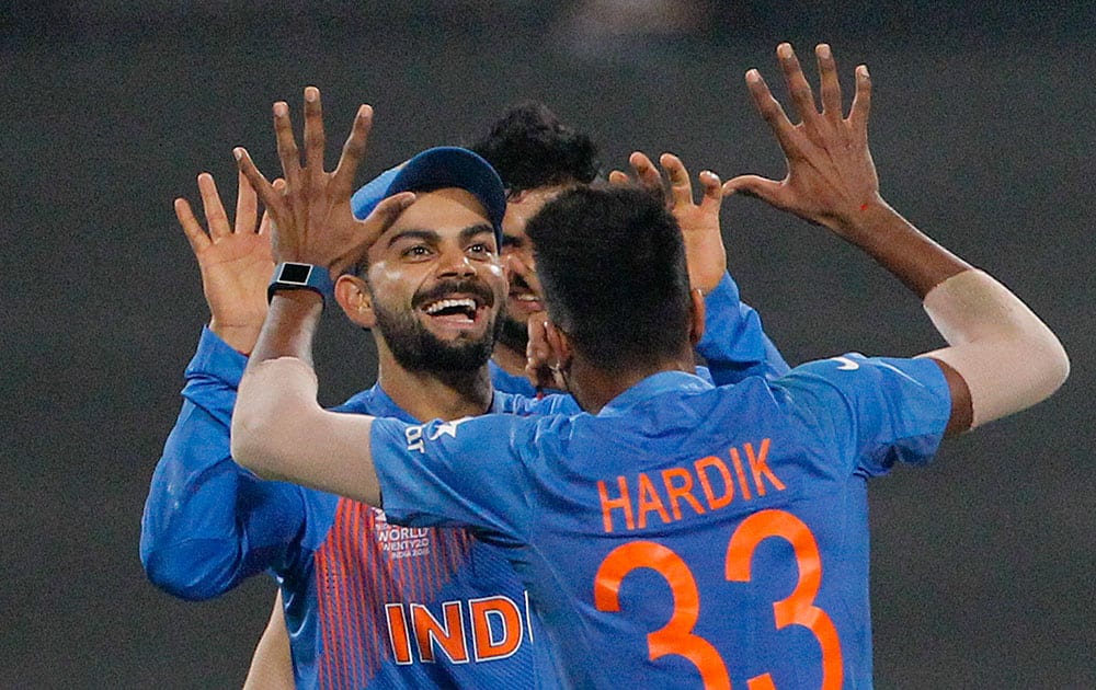 India's Hardik Pandya, back to camera and India's Virat Kohli celebrate the dismissal of Pakistan's Shahid Afridi during the ICC World Twenty20 2016 cricket match at Eden Gardens in Kolkata.