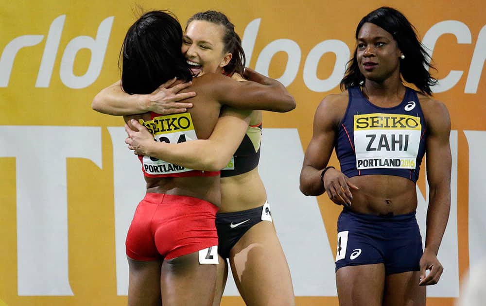 United States' Barbara Pierre, left, is hugged by Germany's Chantal Butzek, center, as France's Carole Zahi, right, looks on, after Pierre won a heat of the women's 60-meter sprint during the World Indoor Athletics Championships.