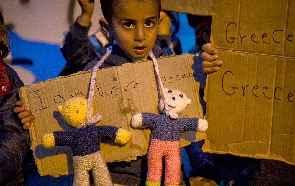 A child holds an improvised banner during a protest by migrants demanding the opening of the border with Macedonia at the northern Greek border point of Idomeni, Greece.