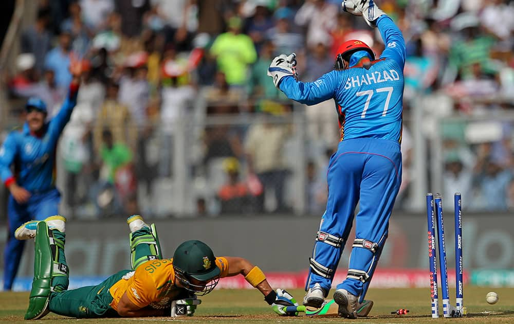 South Africa's captain Faf du Plessis fails to reach the crease as Afghanistan’s Mohammad Shahzad appeals successfully for run out during their ICC World Twenty20 2016 cricket match at the Wankhede stadium in Mumbai.