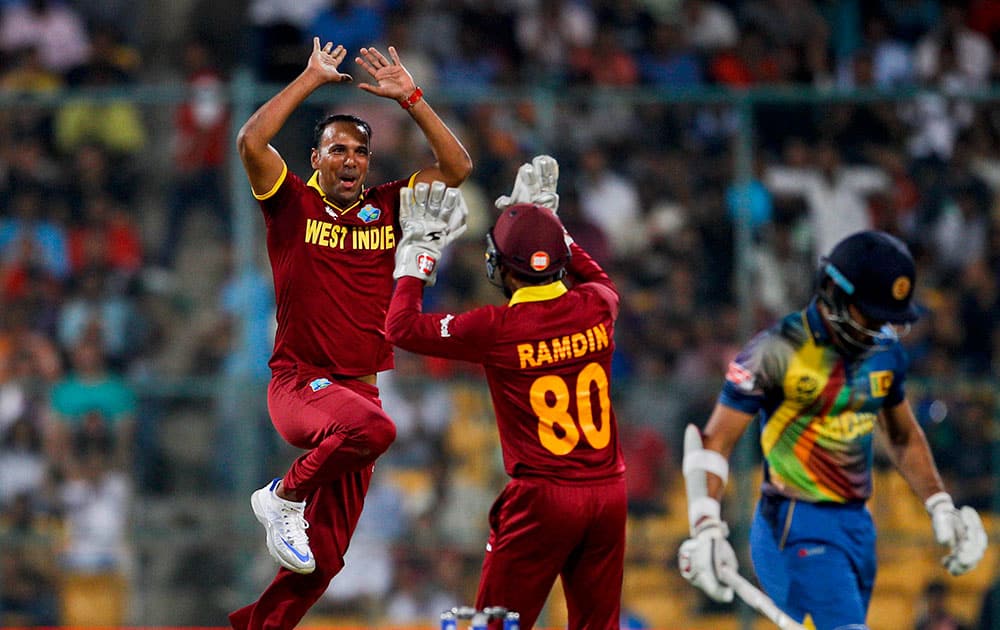 West Indies’ Samuel Badree, left, celebrates after taking the wicket of Sri Lanka's Milinda Siriwardana, right, during their ICC World Twenty20 2016 cricket match in Bangalore.