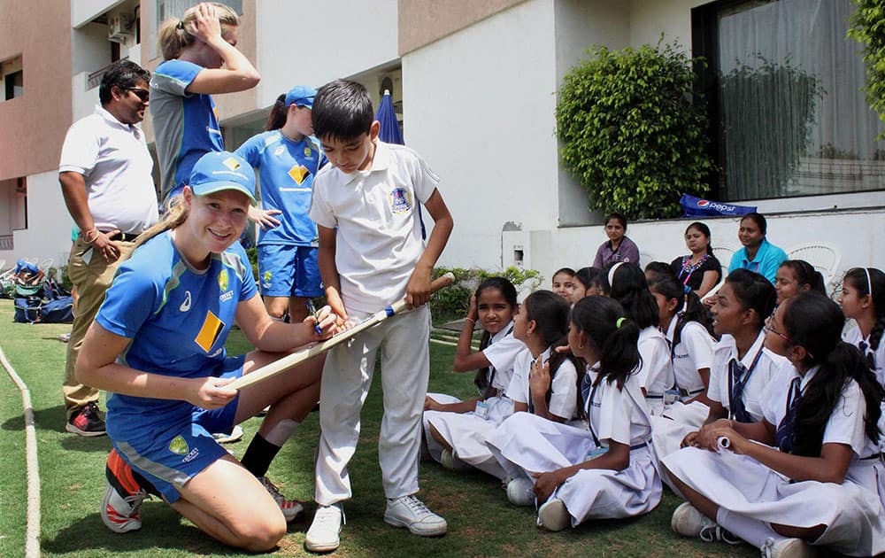 Australian women cricket team players giving autographs to the students during the practise session at the VCA stadium in Nagpur.