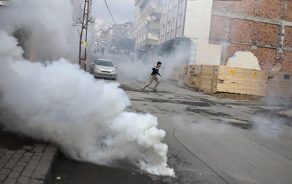 A man runs as demonstrators set a barricade on fire as they clash with security forces, during banned Nowruz celebrations in Istanbul.