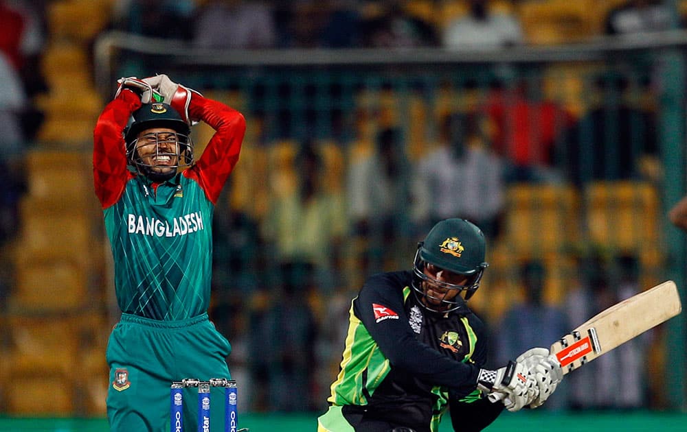 Bangladesh's wicketkeeper Mushfiqur Rahim, left, reacts after Australia's Usman Khawaja, center, missed to play a shot during their ICC World Twenty20 2016 cricket match in Bangalore.