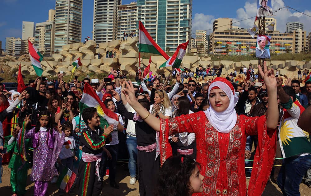 Kurdish citizens who live in Lebanon wear traditional clothes as they dance and wave Kurdish flags, during a celebration of Nowruz day, in Beirut, Lebanon.