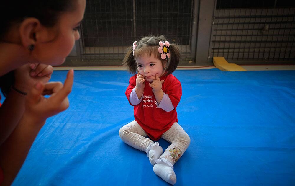 3 year-old Ilinca, blows a kiss to a steward after completing a gymnastics routine during a competition marking the World Down Syndrome Day, in Bucharest, Romania.