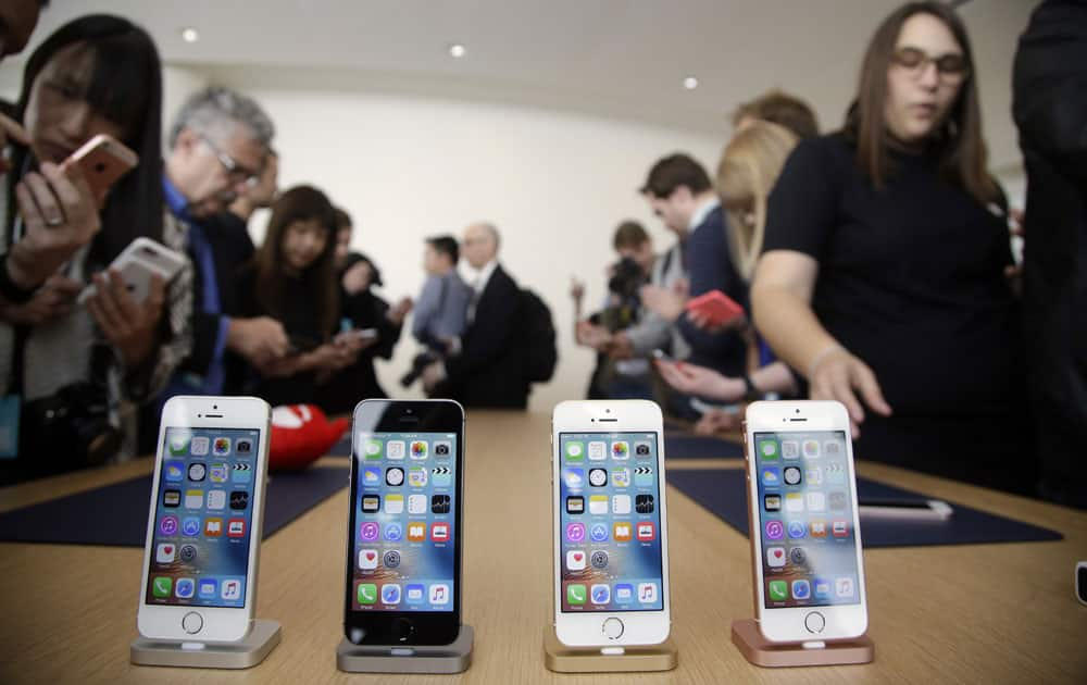 Members of the media and invited guests take a look at the new iPhone SE during an event at Apple headquarters Monday, March 21, 2016, in Cupertino, California.