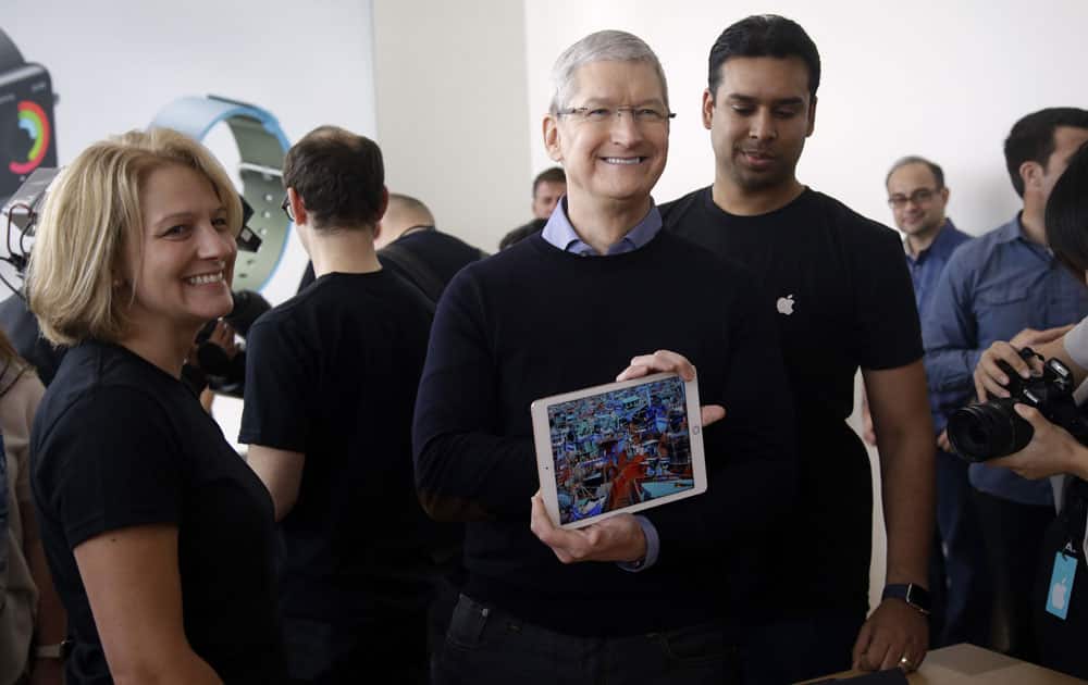 Apple CEO Tim Cook, shows off a new iPad during an event at Apple headquarters Monday, March 21, 2016, in Cupertino, California.

