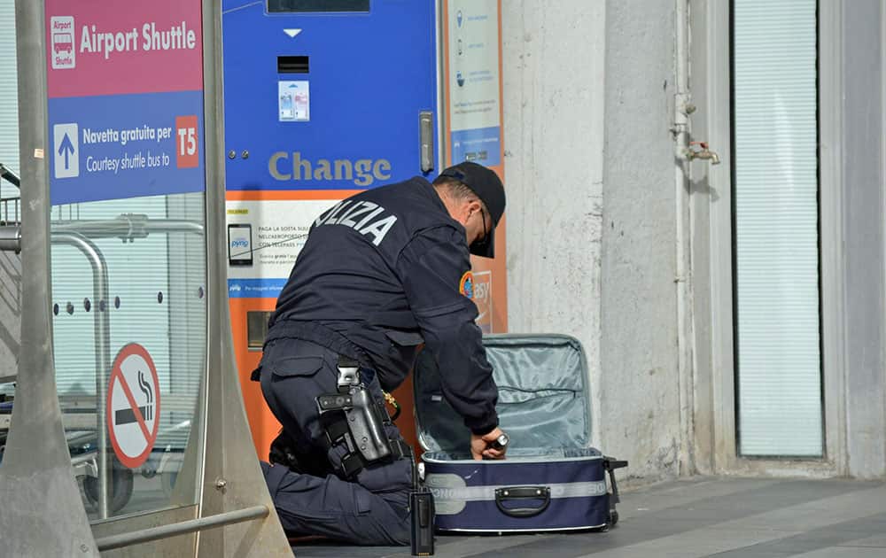 A police officer searches through a suitcase at Fiumicino airport, near Rome, Tuesday, March 22, 2016. The Italian Interior Ministry announced heightened security measures at major Italian airports following explosions at the Brussels airport and the subway system earlier Tuesday.