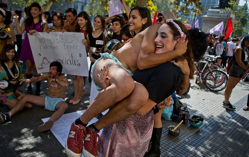 Woman holds a man dressed as baby, during a pro-abortion protest in Santiago, Chile.