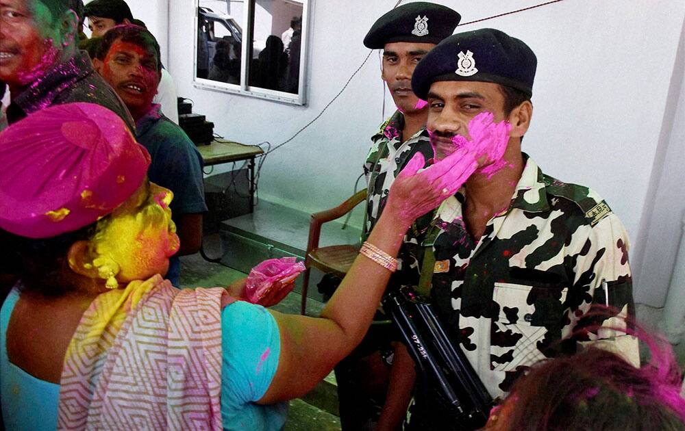 A LJP woman plays color with jawans at party office during Holi Milan function in Patna.