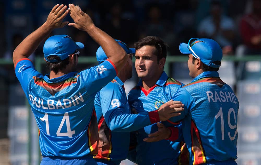 Afghanistan’s Amir Hamza celebrates with team mates after claiming the wicket of England's Jason Roy during their ICC Twenty20 2016 Cricket World Cup match at the Feroz Shah Kotla cricket stadium in New Delhi.