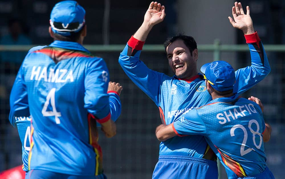 Afghanistan's Mohammad Nabi celebrates with team mates after claiming the wicket of England's Joe Root during their ICC Twenty20 2016 Cricket World Cup match at the Feroz Shah Kotla cricket stadium in New Delhi.