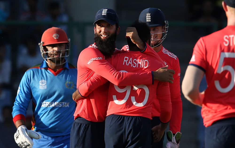 England's Moeen Ali and Jos Buttler congratulate, Adil Rashid, for taking the wicket of Afghanistan's Noor Ali Zadran at the ICC Twenty20 2016 Cricket World Cup match at the Feroz Shah Kotla cricket stadium in New Delhi.