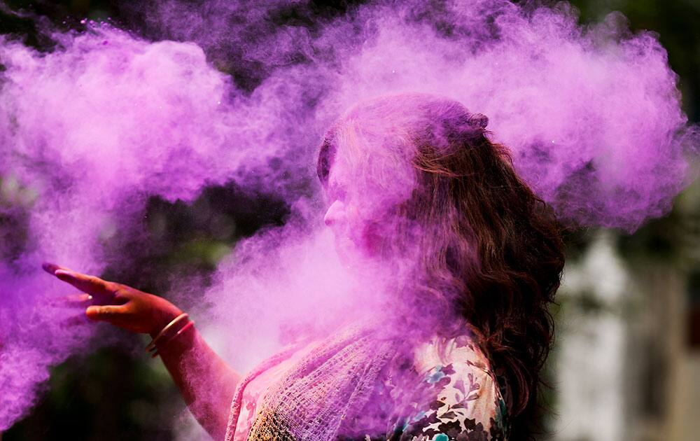 A Bangladeshi woman shuts her eyes as colored powder is smeared on her face during celebrations marking Holi, the Hindu festival of colors, in Dhaka, Bangladesh.