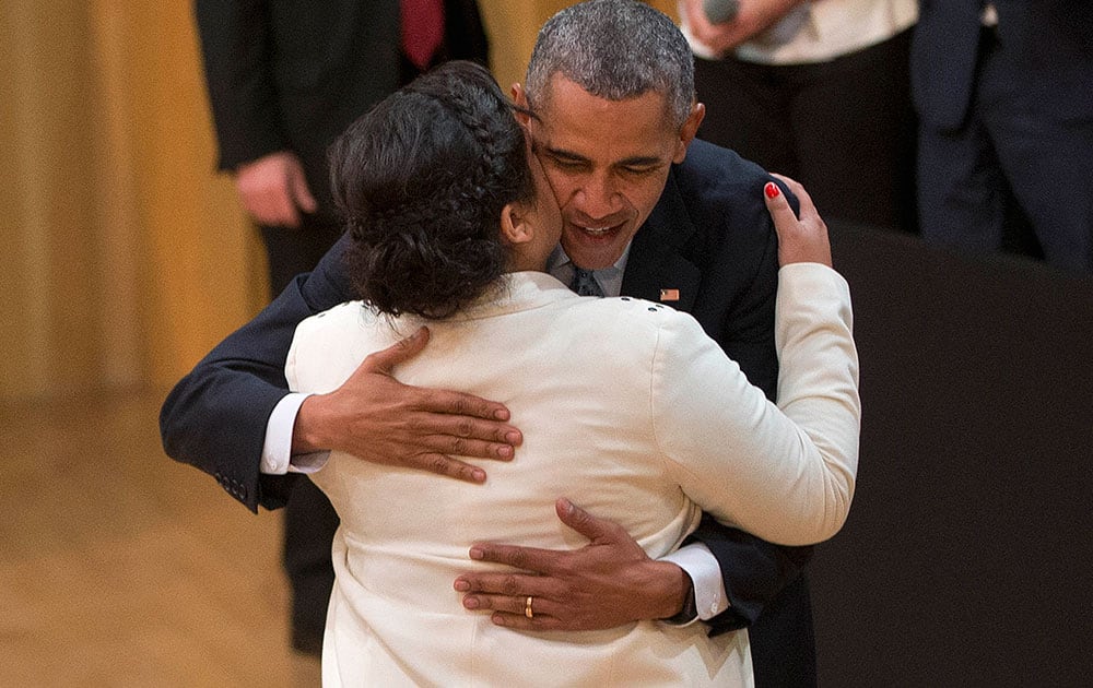 President Barack Obama hugs Celeste Medina after she introduced him for a town hall meeting with local Argentinians at the Usina del Arte.