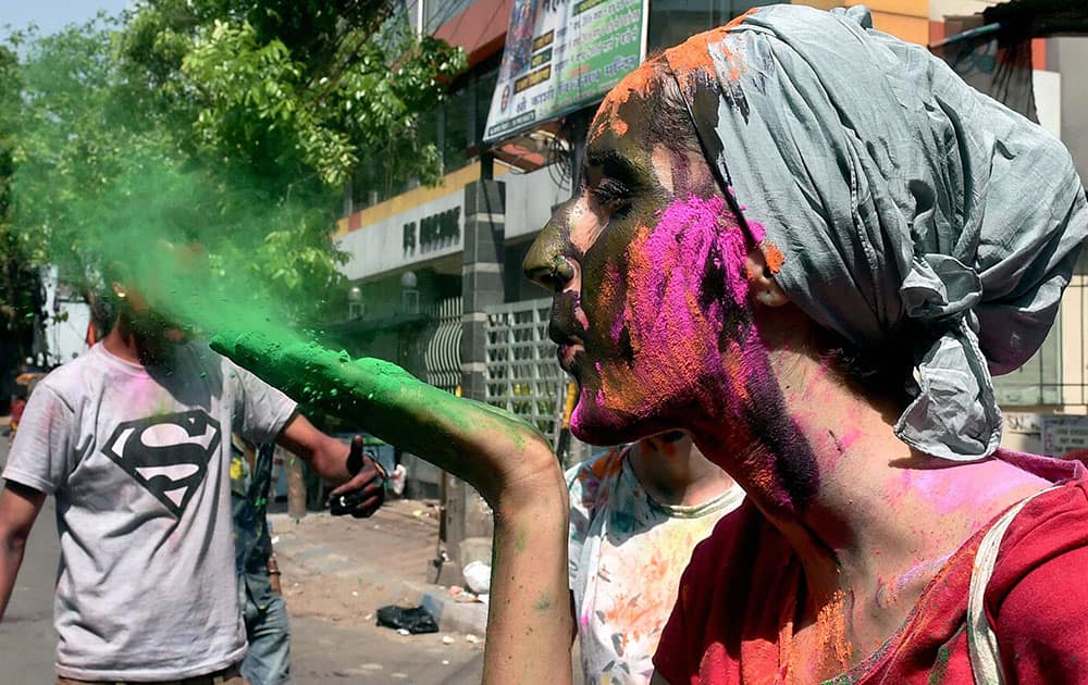 A Foreign tourist sprays colour while celebrating Holi in Kolkata.