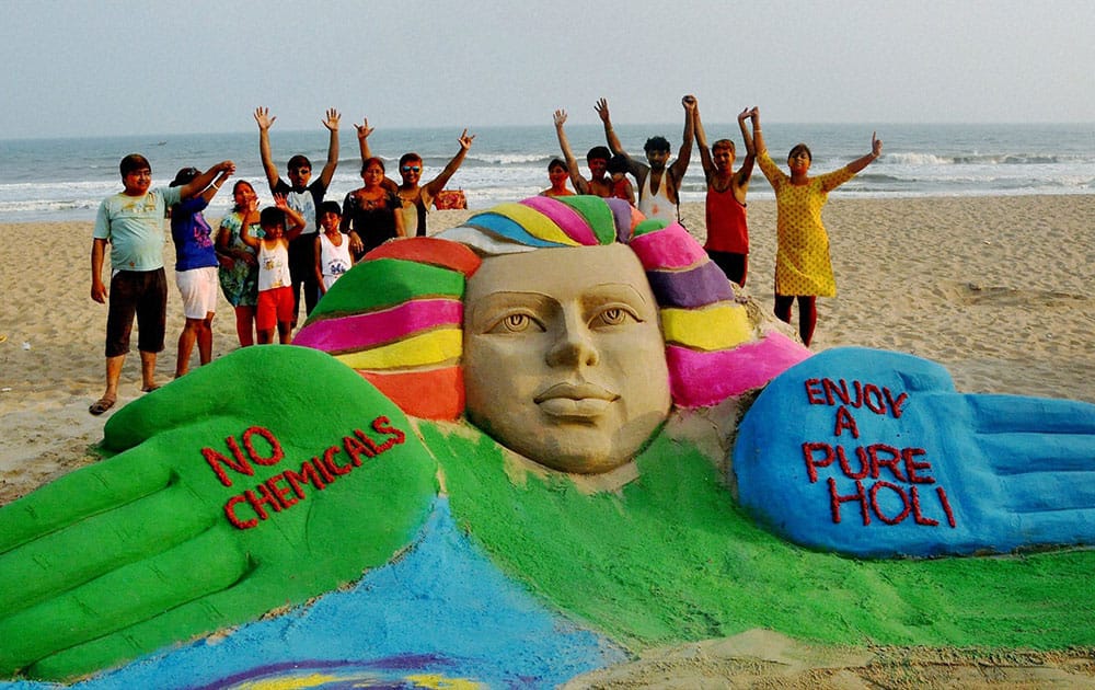 Sand artist Manas Kumar Sahoo creates a sand sculpture on eve of Holi festival at Puri.