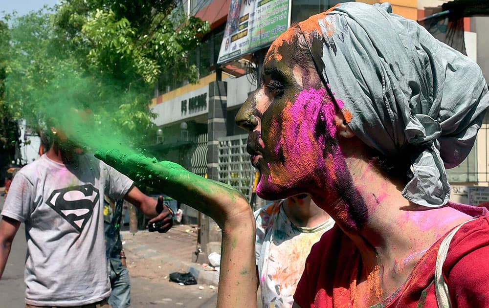 A Foreign tourist sprays colour while celebrating Holi in Kolkata.
