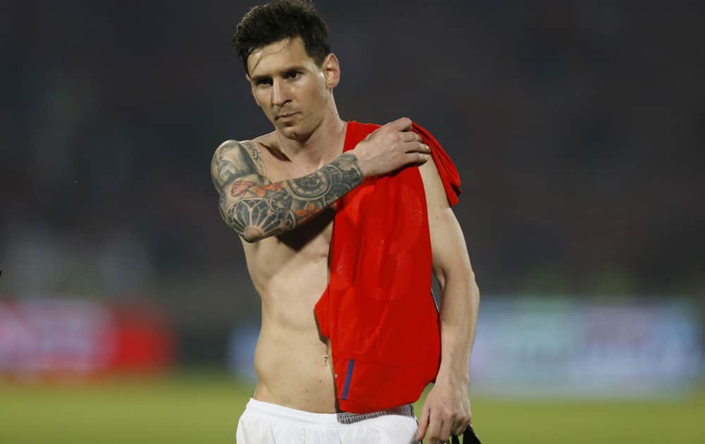 Argentina's Lionel Messi leaves the field carrying the shirt of Chile's Gonzalo Jara after a 2018 Russia World Cup qualifying soccer match at the National Stadium in Santiago, Chile. Argentina won 2-1.