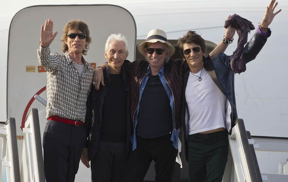 Members of The Rolling Stones, from, Mick Jagger, Charlie Watts, Keith Richards and Ron Wood pose for photos from the plane that brought them to Cuba at Jose Marti international airport in Havana, Cuba.