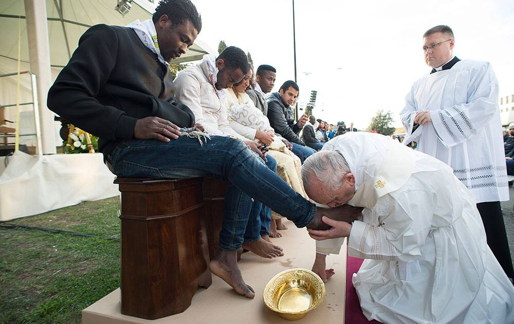 Pope Francis kisses the foot of a man during the foot-washing ritual at the Castelnuovo di Porto refugees center, some 30km (18, 6 miles) from Rome.