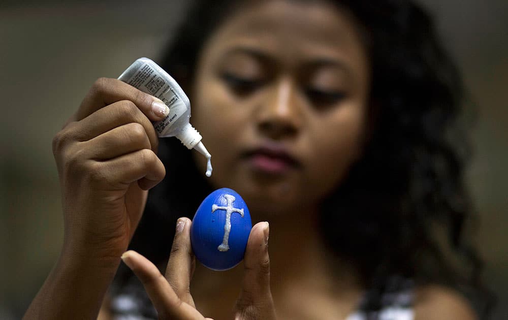 An Indian Christian decorates an Easter egg at a church on the eve of Easter Sunday in Gauhati, India.